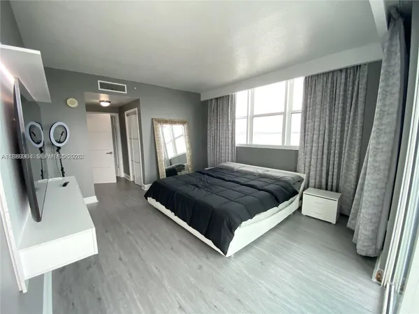 a bedroom with a bed a mirror and a window