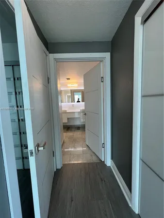 a view of a hallway with wooden floor and a living room