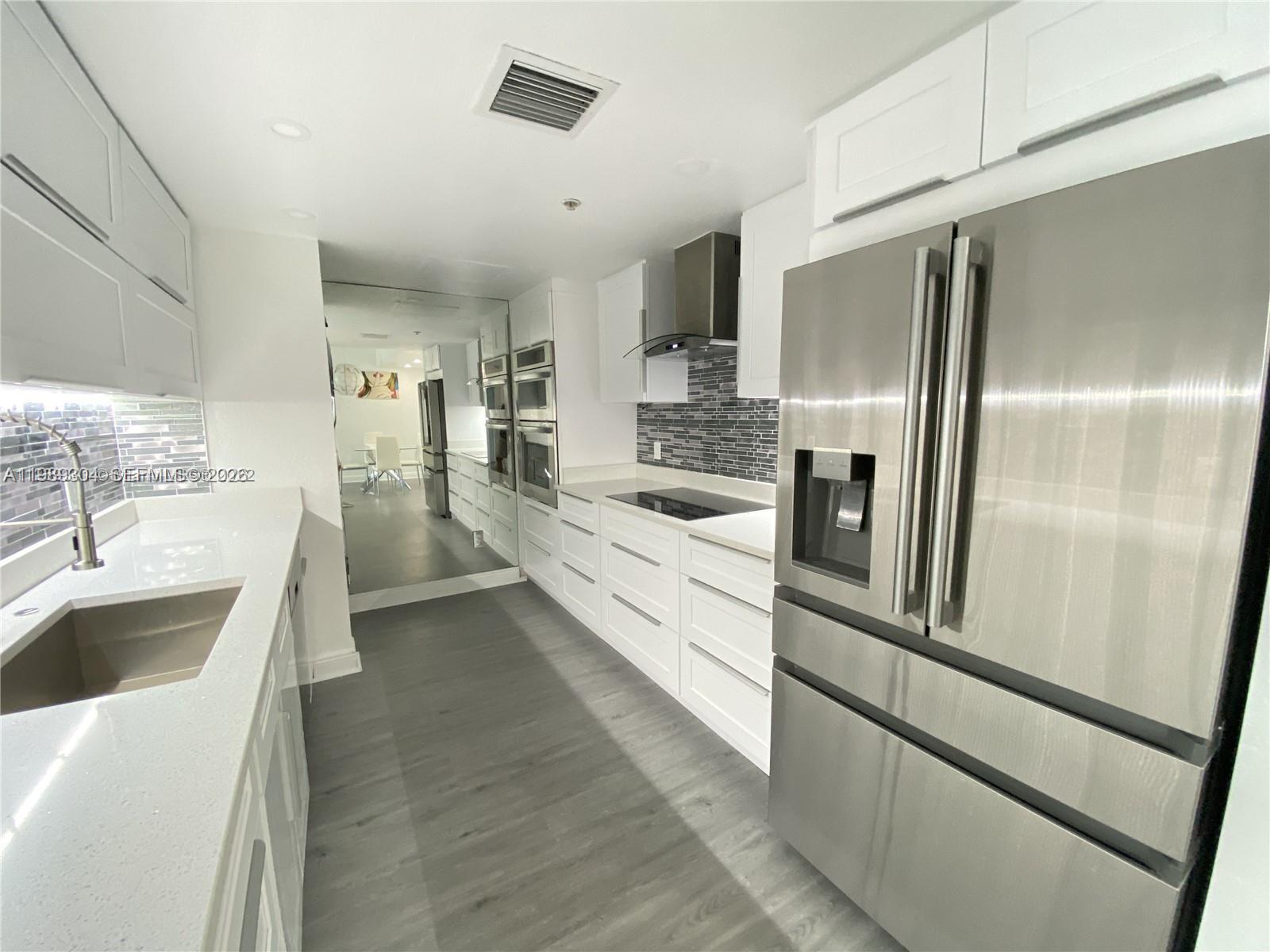 500 Northeast 29th Street, Unit 608 Miami, FL 33137 - Photo 6 of 36 a large white kitchen with a sink stainless steel appliances and cabinets