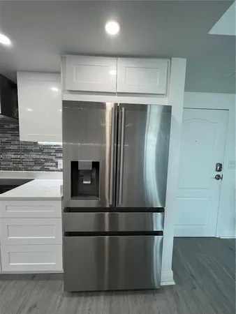 a view of a refrigerator in kitchen and wooden floor