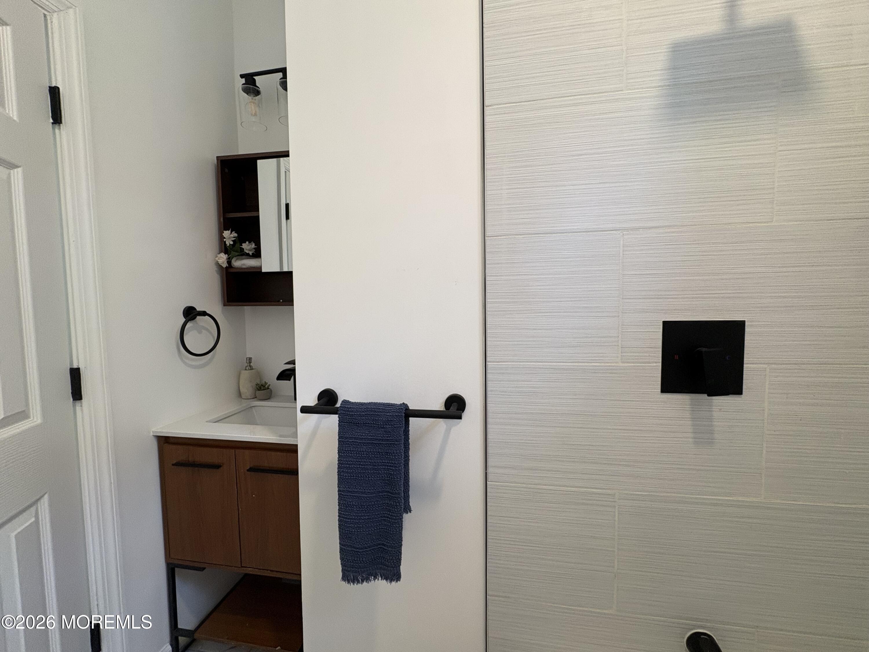 456 Harrison Street, Unit 2 Passaic, NJ 07055 - Photo 14 of 15 a bathroom with a sink a mirror and shower