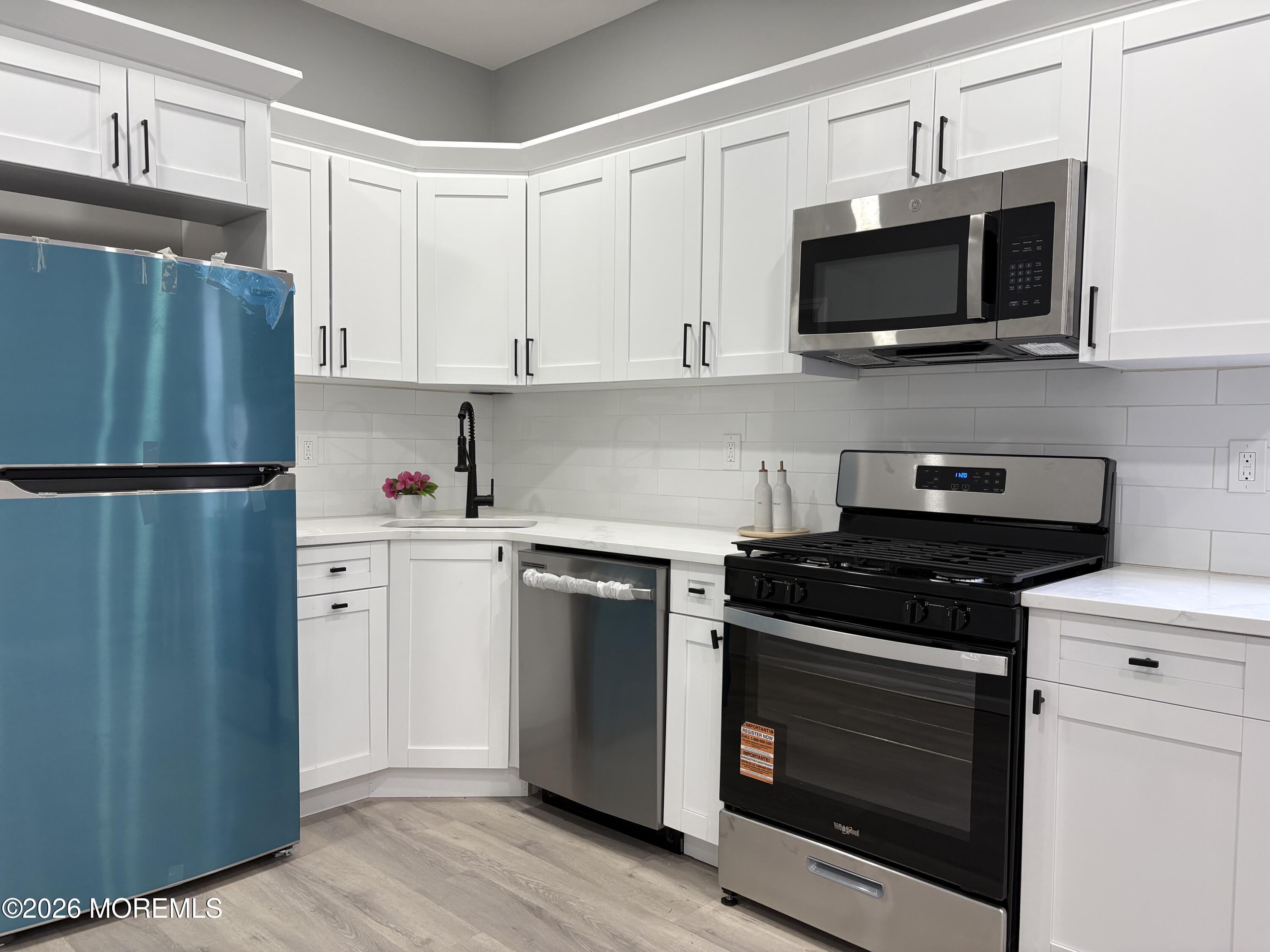 456 Harrison Street, Unit 2 Passaic, NJ 07055 - Photo 6 of 15 a kitchen with a stove and a microwave