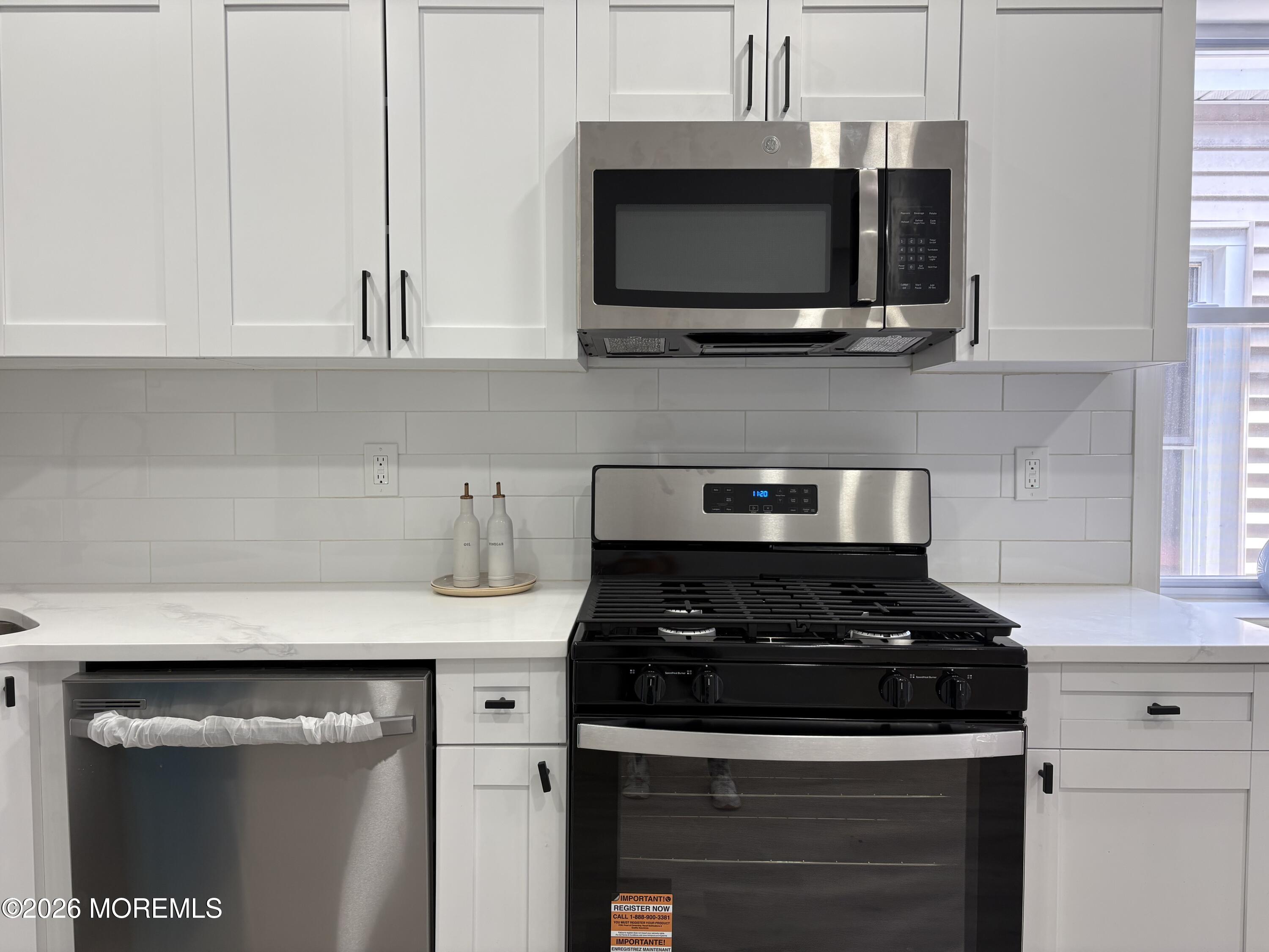 456 Harrison Street, Unit 2 Passaic, NJ 07055 - Photo 7 of 15 a kitchen with stainless steel appliances granite countertop white cabinets and black stove top oven with granite countertops