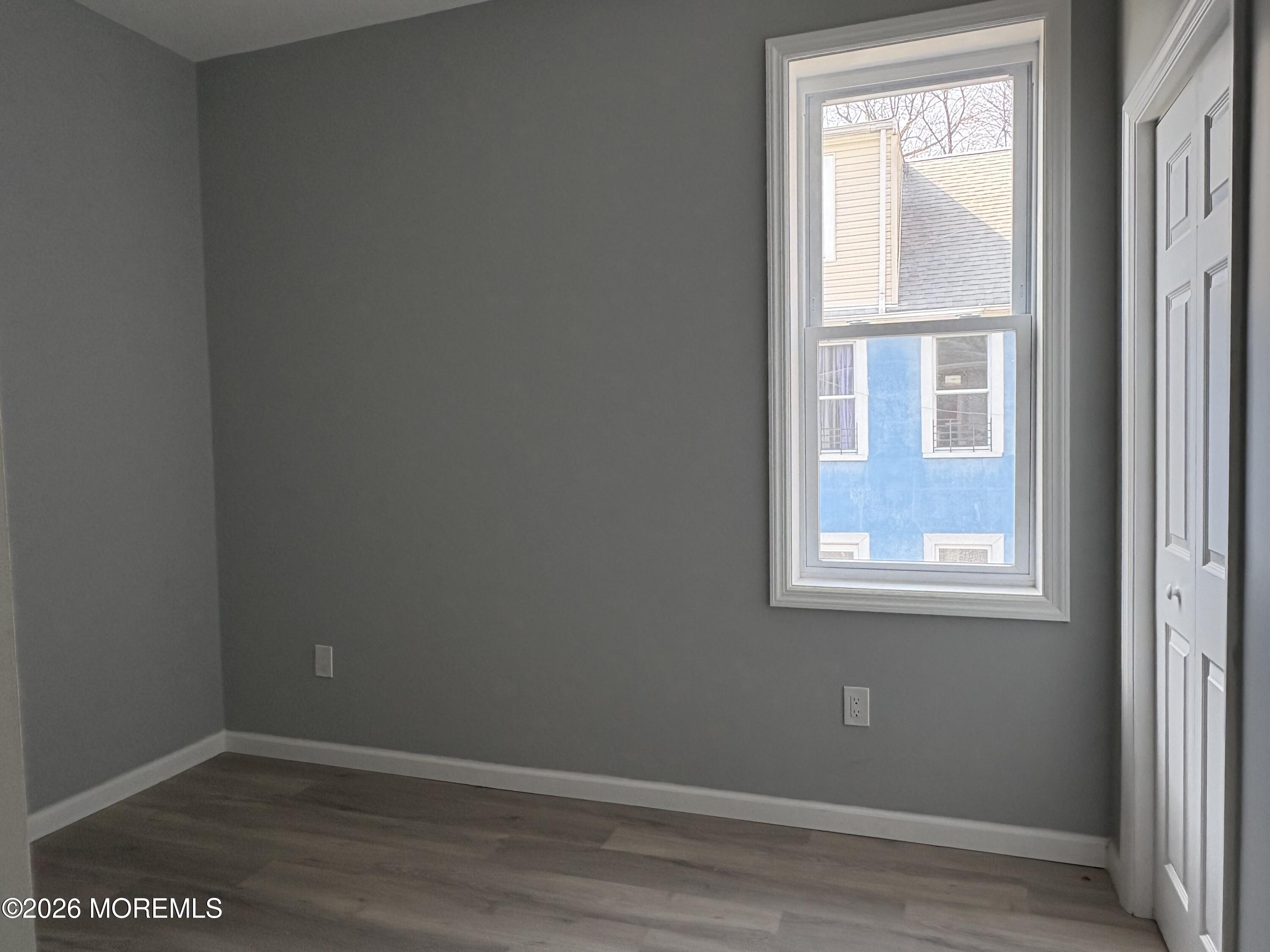 456 Harrison Street, Unit 2 Passaic, NJ 07055 - Photo 10 of 15 an empty room with wooden floor and windows
