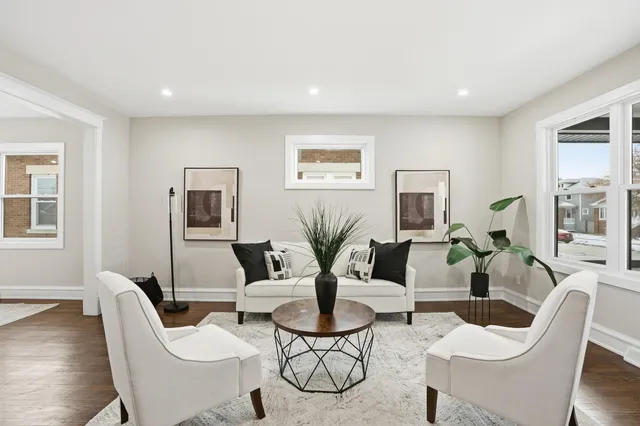 a living room with patio furniture and a potted plant