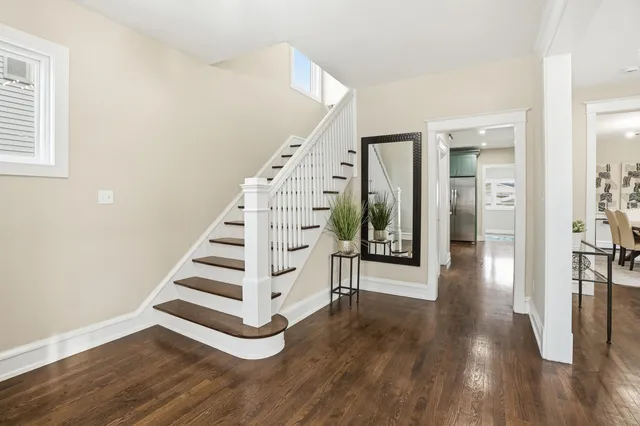 a view of a hallway with wooden floor and stairs