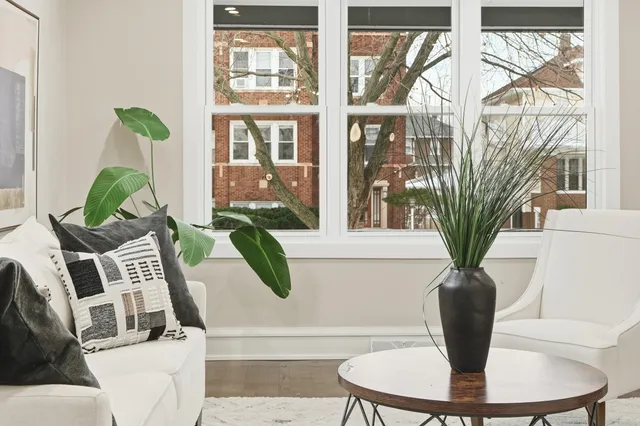 a vase of flowers sitting on a table with wooden floor