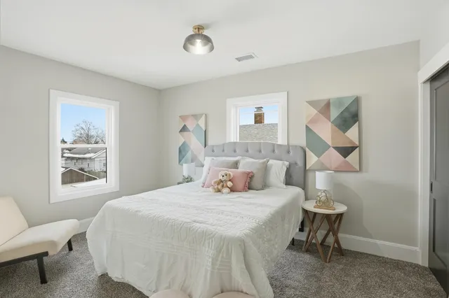 a bedroom with a bed and a painting on the wall