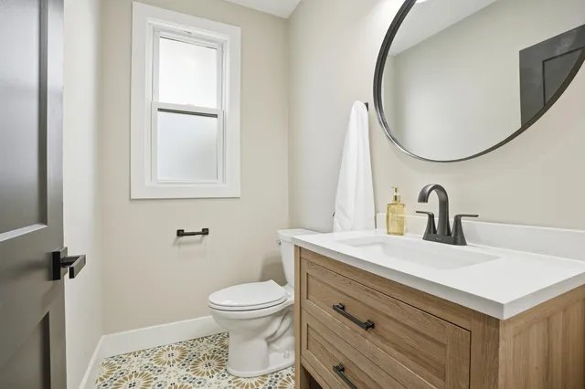 a bathroom with a sink toilet and a mirror
