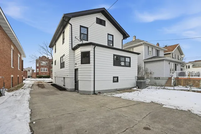 a view of a white house with a large space in front of it