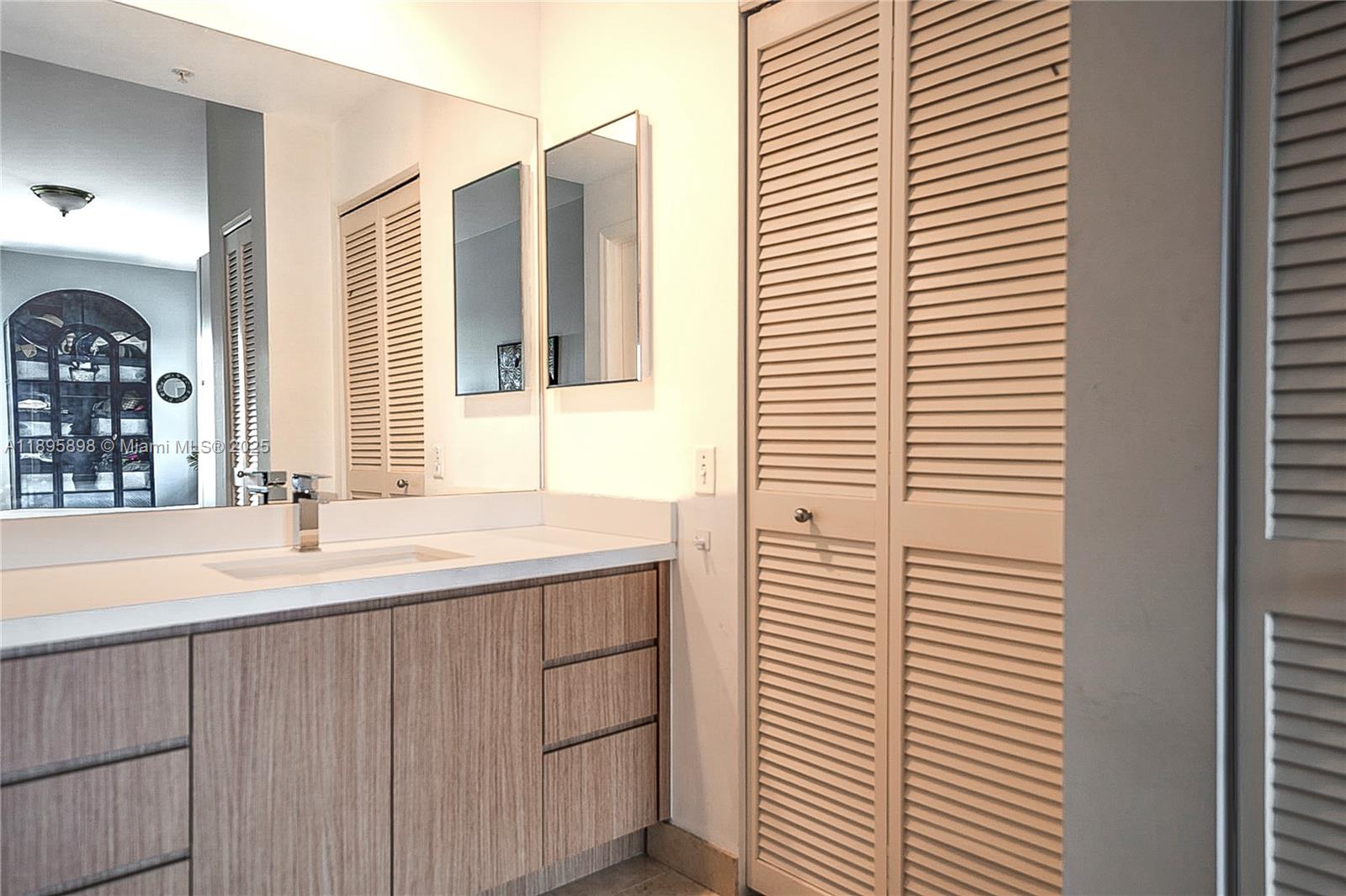 888 Brickell Key Drive, Unit 903 Miami, FL 33131 - Photo 11 of 38 a bathroom with a sink and a large mirror