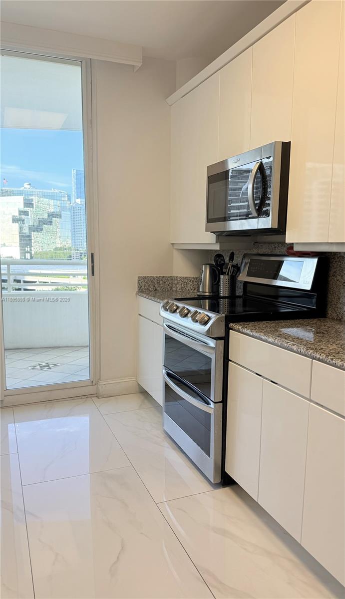 888 Brickell Key Drive, Unit 903 Miami, FL 33131 - Photo 19 of 38 a kitchen with a stove and a microwave