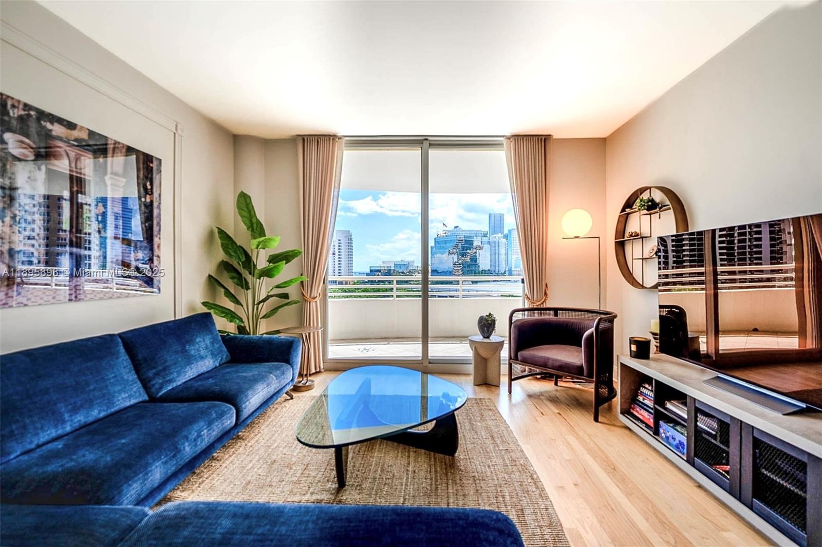 888 Brickell Key Drive, Unit 903 Miami, FL 33131 - Photo 5 of 38 a living room with furniture a wooden floor and a floor to ceiling window