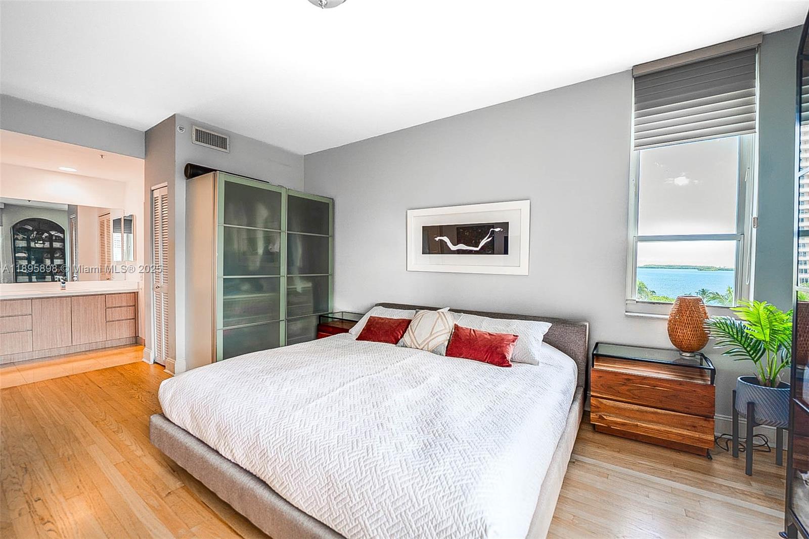 888 Brickell Key Drive, Unit 903 Miami, FL 33131 - Photo 8 of 38 a bedroom with a large bed and a potted plant