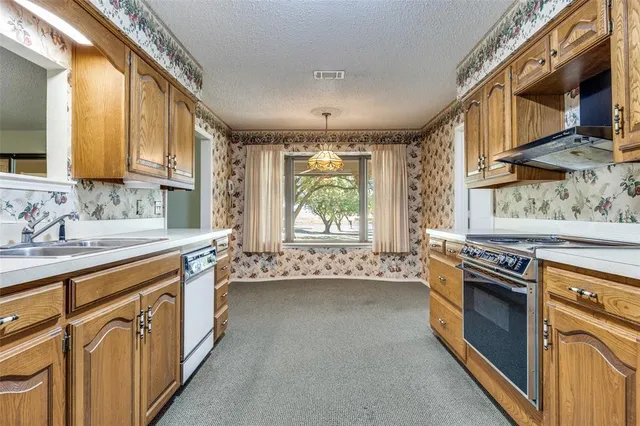 a kitchen with stainless steel appliances granite countertop a stove and a sink