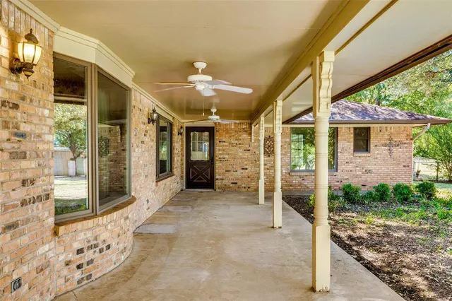 a view of a porch with a table and chairs and floor to ceiling window