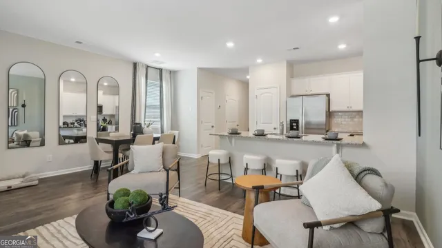 a living room with furniture kitchen view and a potted plant