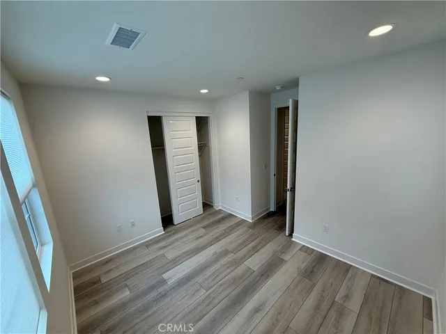 an empty room with wooden floor and entrance