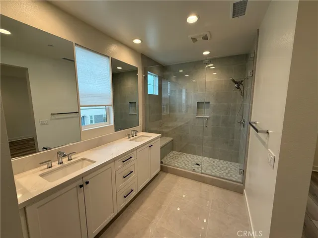 a bathroom with a mirror a double vanity sink and mirror