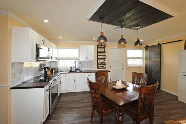 a kitchen with a table chairs stove and cabinets
