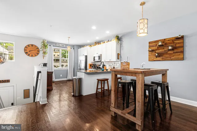 a dining room with wooden floor a chandelier a wooden table and chairs