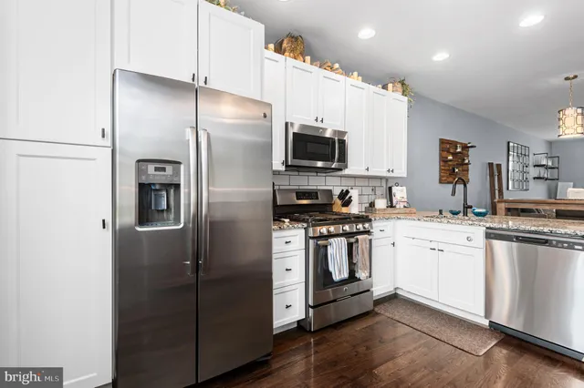 a kitchen with stainless steel appliances a refrigerator sink and microwave