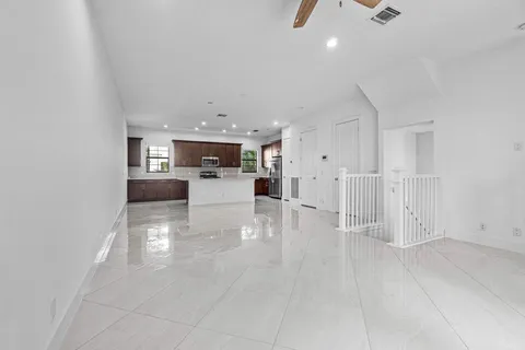 a view of a living room and kitchen with furniture appliances