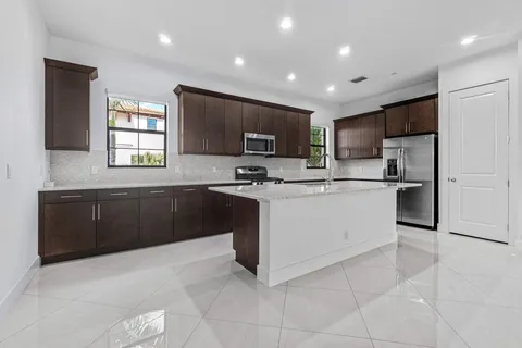 a kitchen with granite countertop a refrigerator sink and cabinets