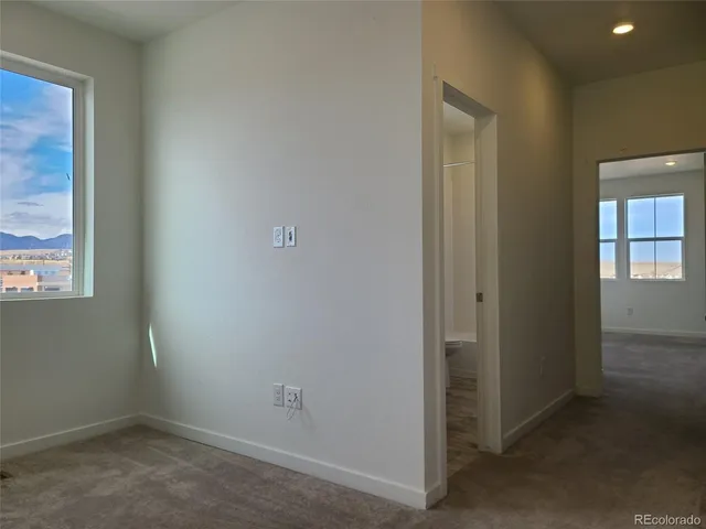 an empty room with windows and closet