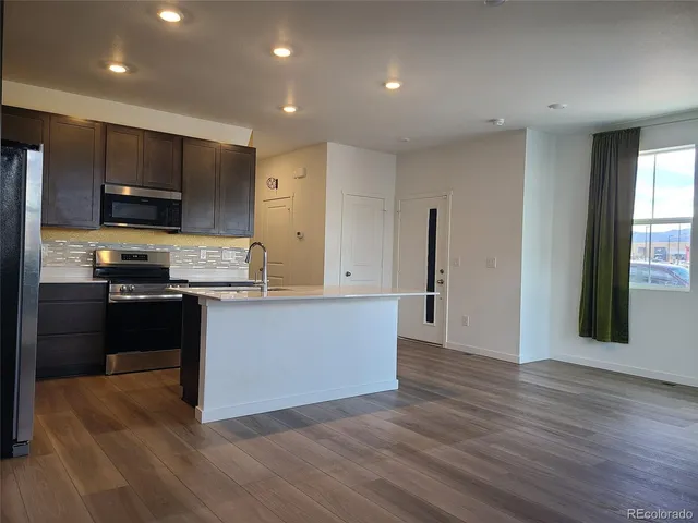 a kitchen with stainless steel appliances a refrigerator and a stove top oven