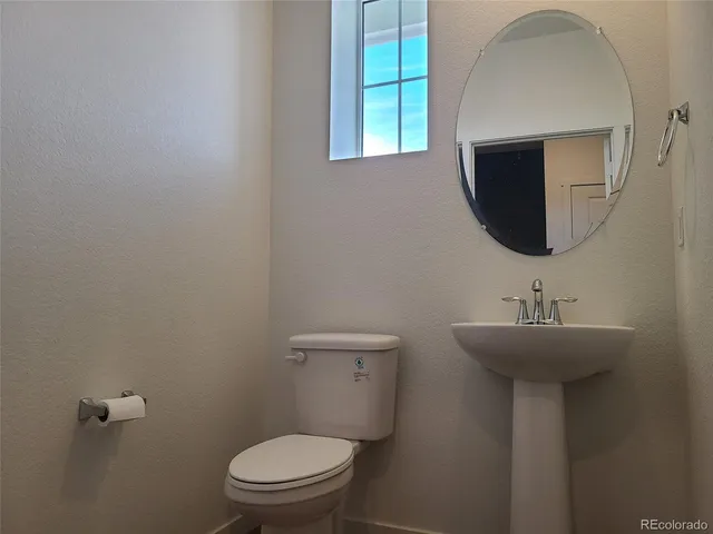 a bathroom with a sink a toilet and mirror