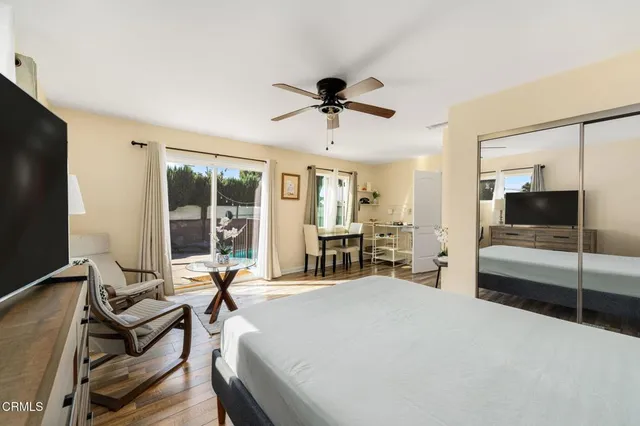 a living room with furniture a flat screen tv and floor to ceiling window