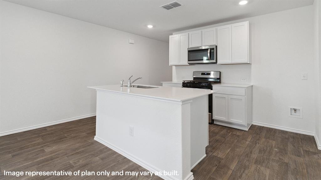 3522 Spring Time Street Forney, TX 75126 - Photo 4 of 27 Open-concept kitchen featuring white cabinetry, stainless steel appliances, a center island with sink, and wood-finish flooring