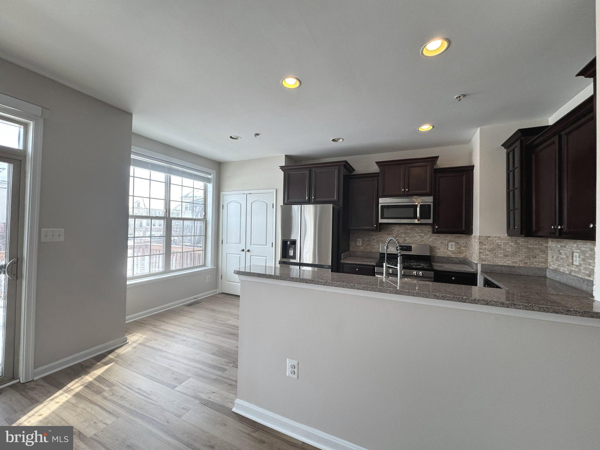 4713 Cambria Road Frederick, MD 21703 - Photo 11 of 67 a kitchen with stainless steel appliances a sink a stove a microwave a refrigerator a window and cabinets