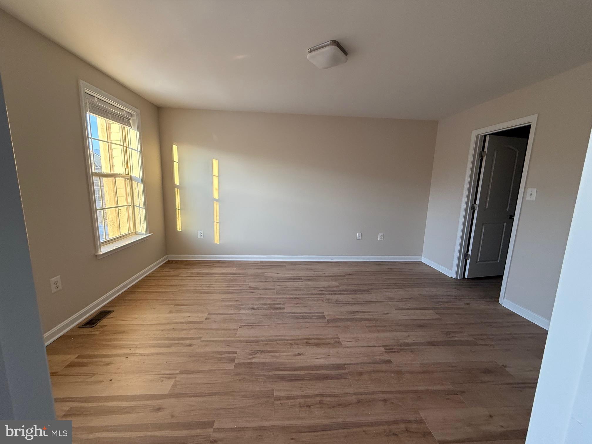 4713 Cambria Road Frederick, MD 21703 - Photo 16 of 67 a view of an empty room with wooden floor and a window