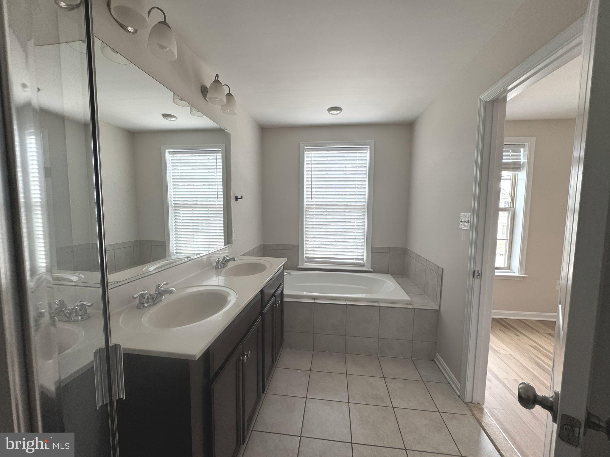 4713 Cambria Road Frederick, MD 21703 - Photo 46 of 67 a spacious bathroom with a granite countertop sink and a mirror