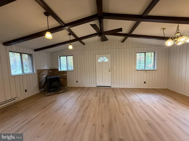 a view of a livingroom with wooden floor and staircase