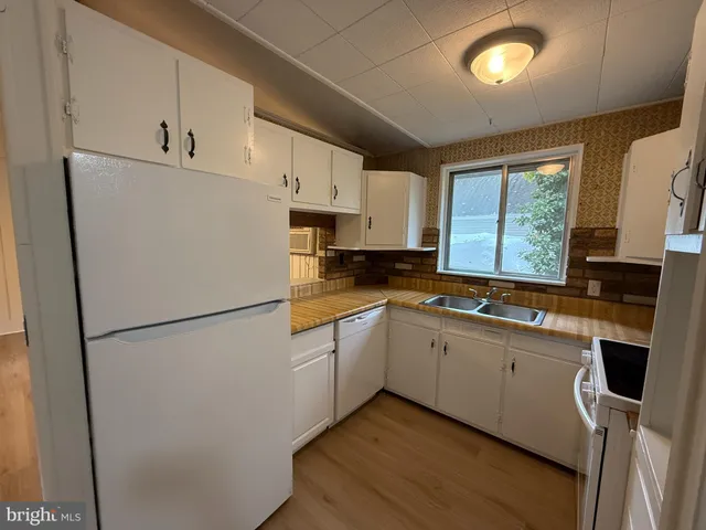 a kitchen with refrigerator a sink and a stove