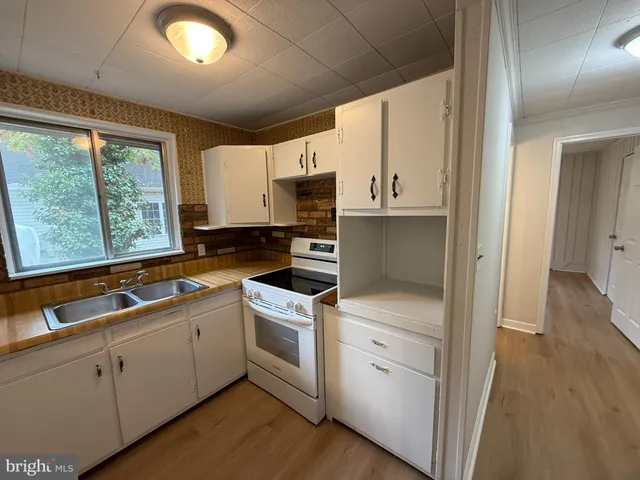 a kitchen with a sink stove and cabinets