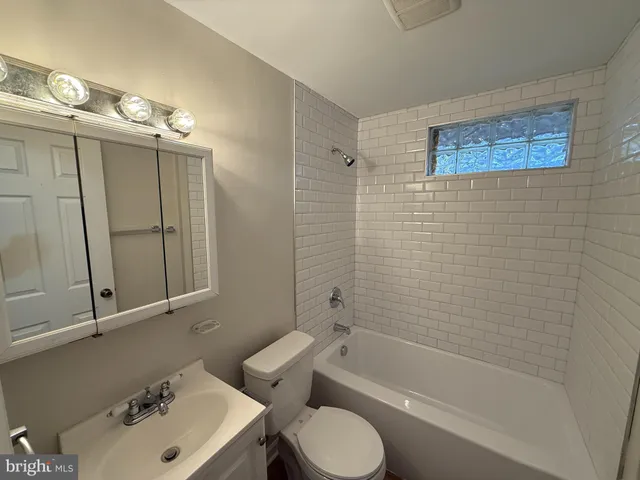a bathroom with a sink mirror toilet and bathtub