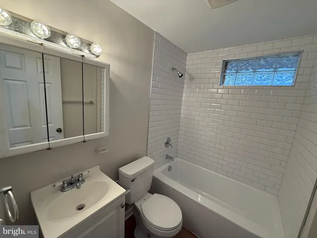 a bathroom with a sink mirror toilet and bathtub