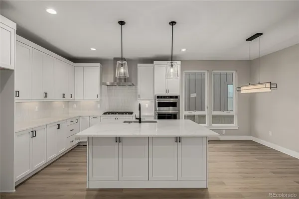 a kitchen with kitchen island a counter top space appliances and cabinets