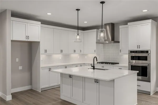 a kitchen with a sink a center island a cabinets and stainless steel appliances
