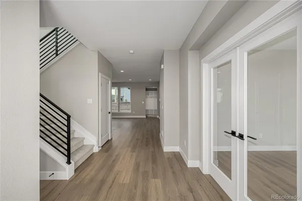 a view of a hallway with wooden floor and staircase