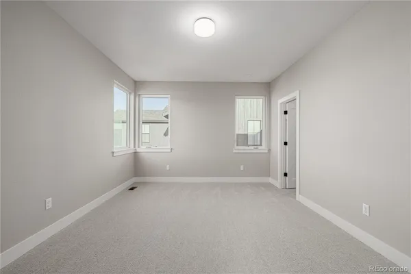 an empty room with windows and closet