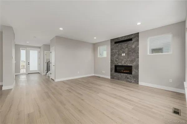 a view of empty room with wooden floor and fireplace