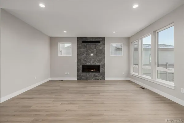 a view of a big room with wooden floor and a fireplace