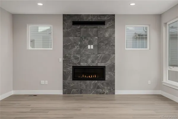 a view of wooden floor fire place and windows in a room