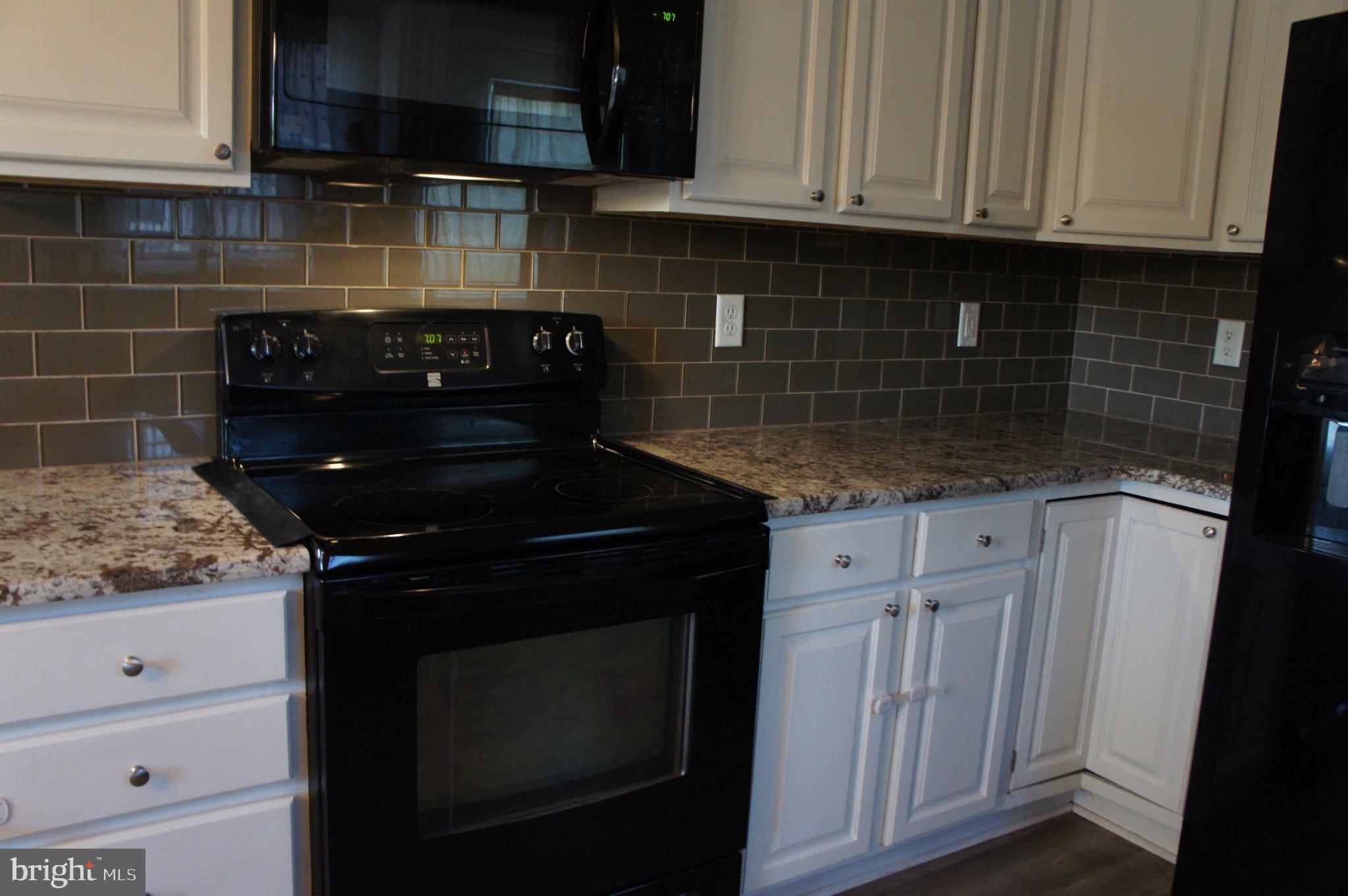 8981 Sharptown Road Laurel, DE 19956 - Photo 12 of 34 Modern kitchen with glass subway tile backsplash.