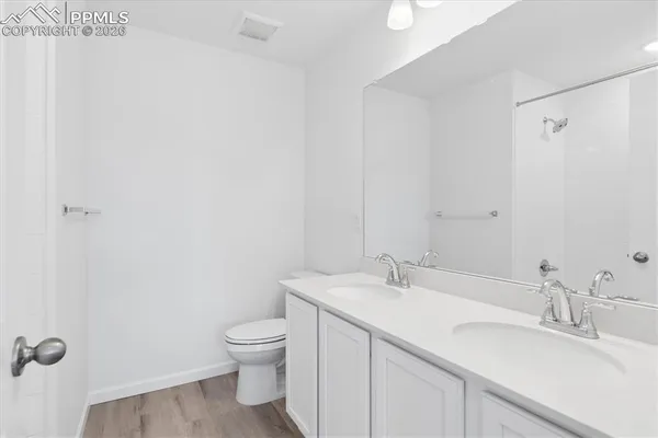 a bathroom with a granite countertop sink a toilet and a mirror
